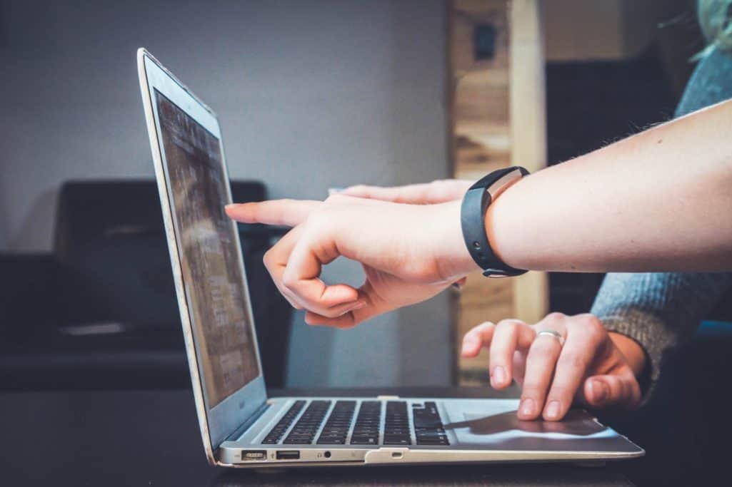 Two people discuss while looking to a computer.